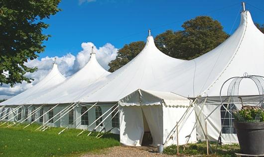 a line of portable toilets in a shaded area, offering a comfortable experience for users in Saunderstown